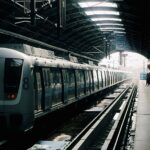 A metro train waiting at a quiet station platform