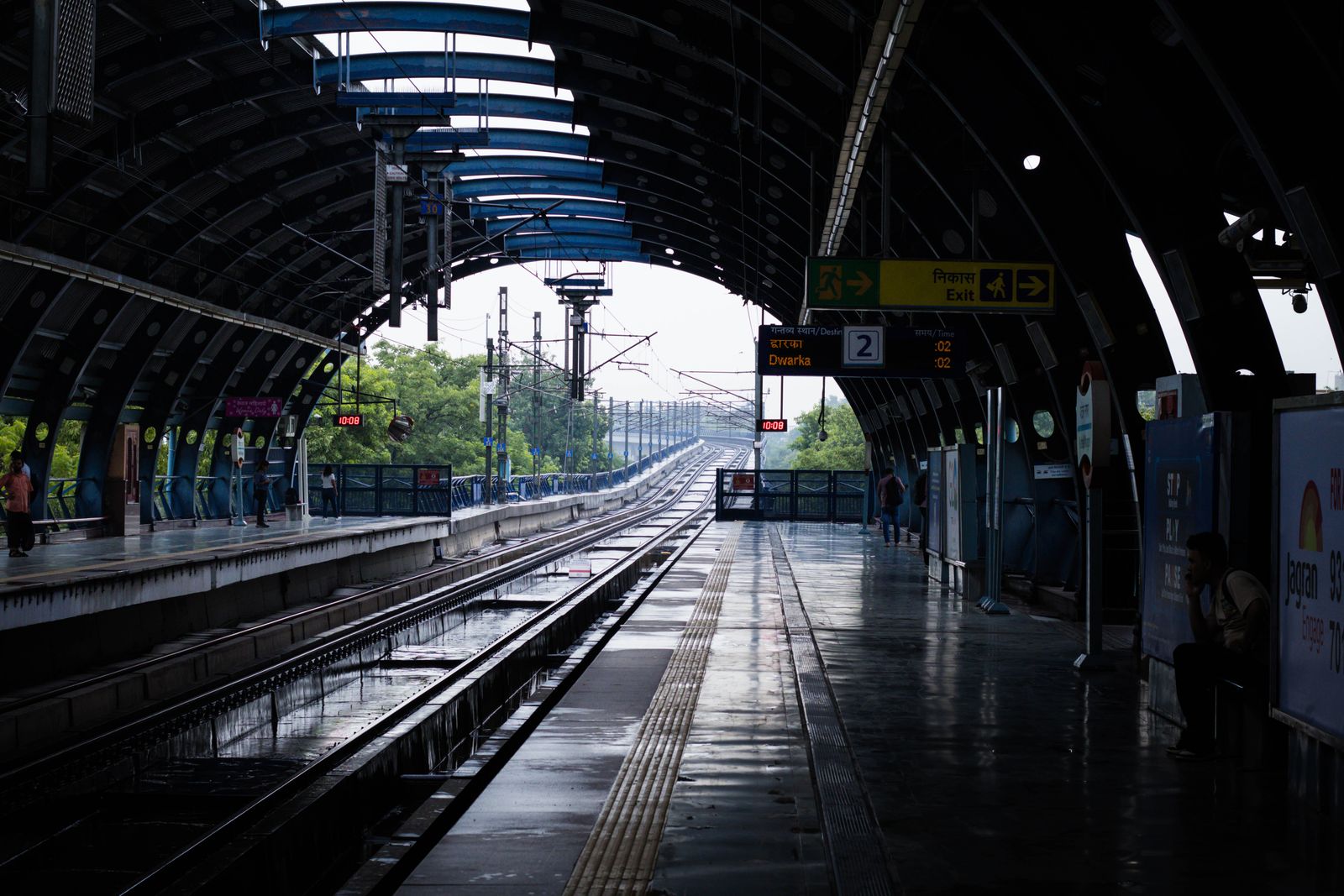 An empty metro station with wet tracks after rain